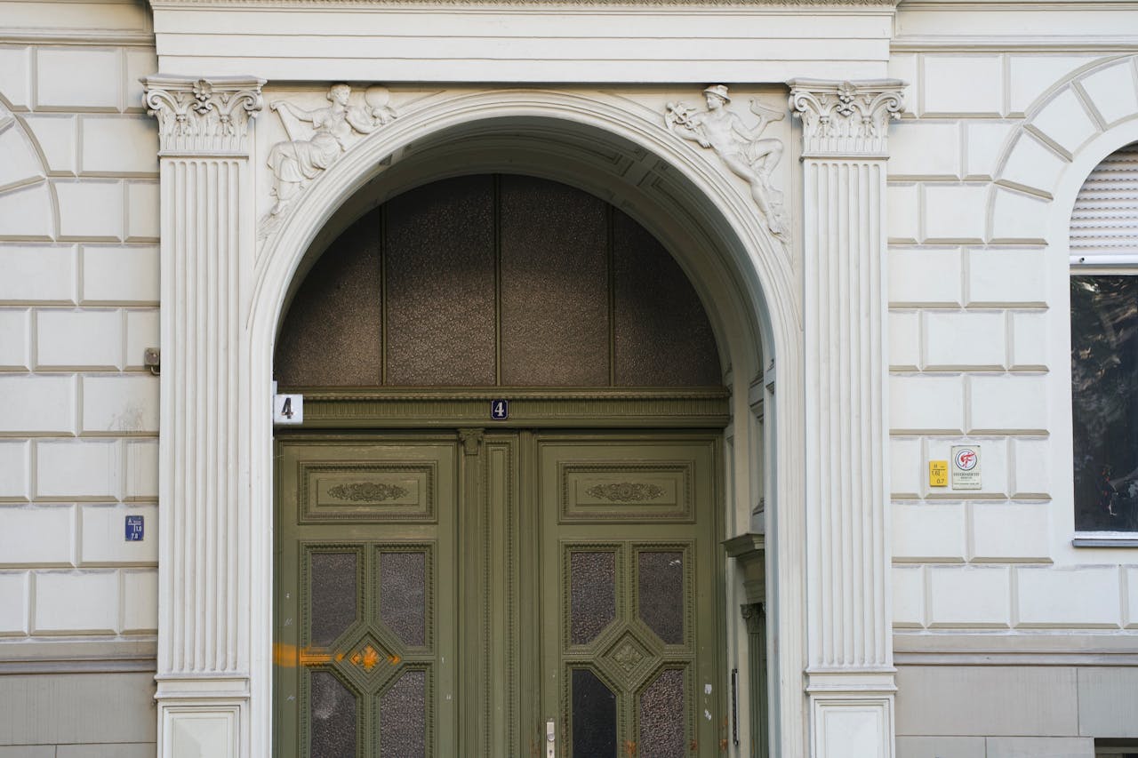 about-01 Ornate green entrance door with classical architectural details in Berlin.